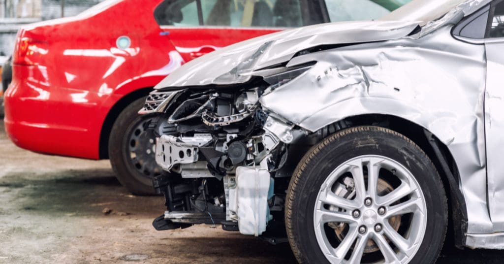 Silver vehicle in a body shop being repaired. 1-800-ASK-GARY explains why you might want to talk to a lawyer.