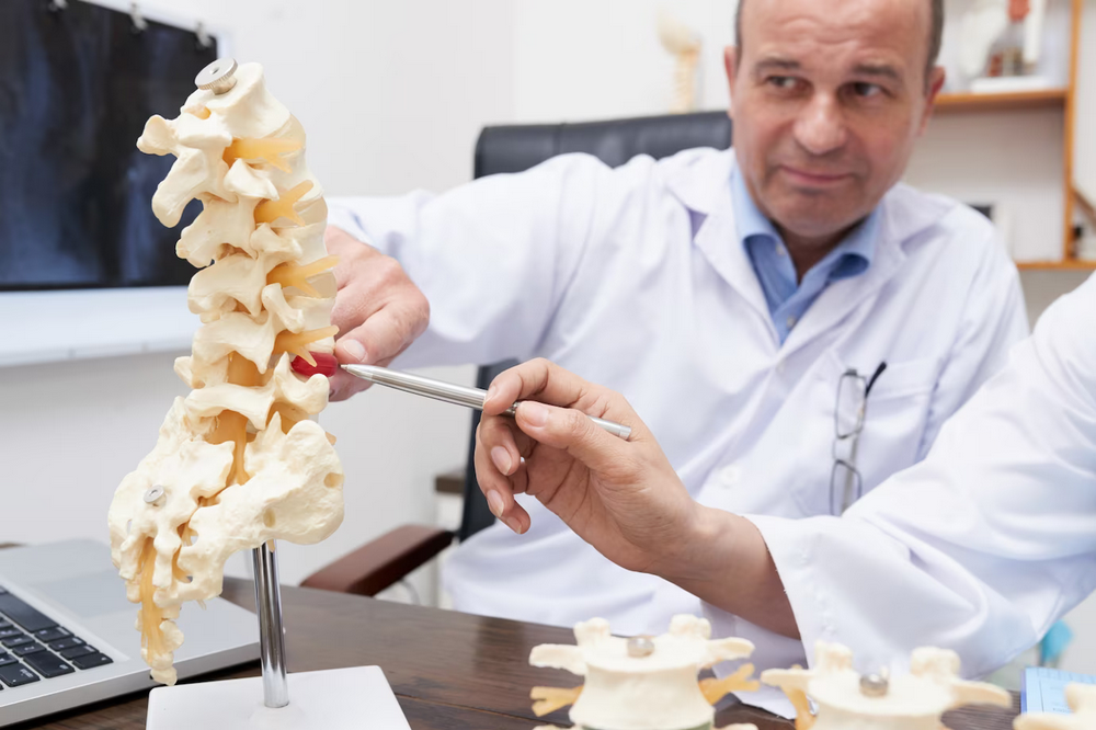 a man is working on a model of a human skeleton.