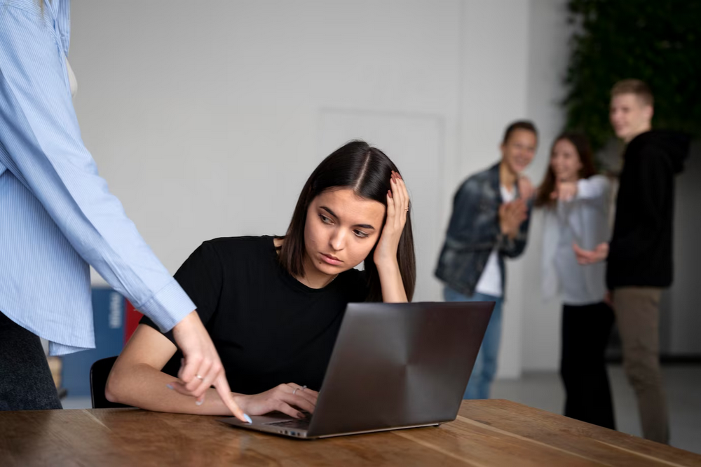 a woman sitting in front of a laptop computer.